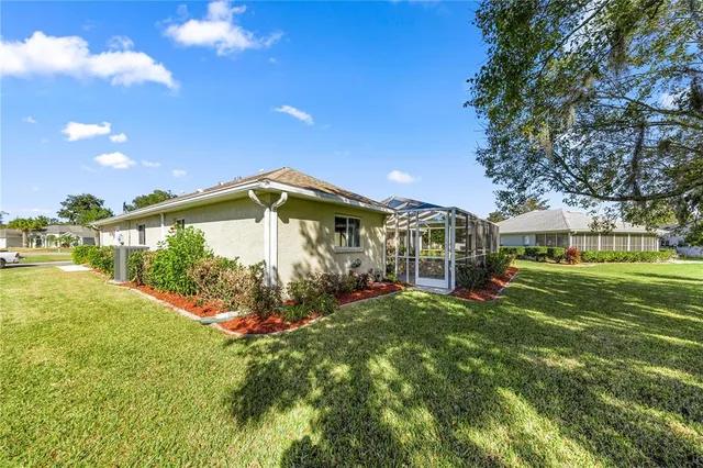 a view of a house with a big yard and large trees