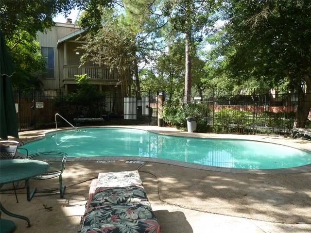 a view of backyard with table and chairs and potted plants and large trees