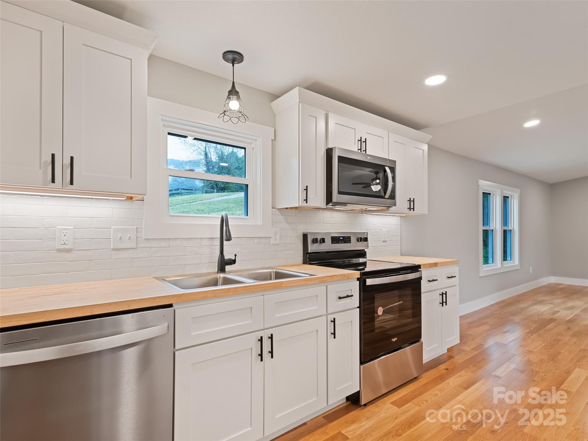 120 Simonds Ridge Canton, NC 28716 - Photo 4 of 36 a kitchen with stainless steel appliances granite countertop white cabinets a stove top oven a sink and dishwasher