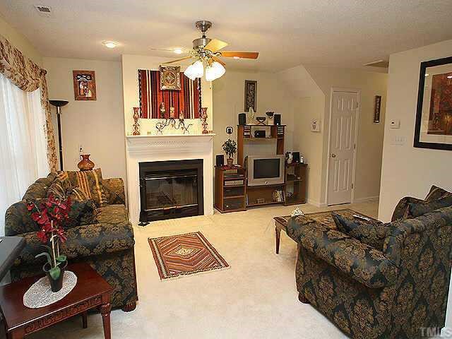 6704 Twin Tree Court Raleigh, NC 27613 - Photo 3 of 11 a living room with furniture a fireplace and a flat screen tv