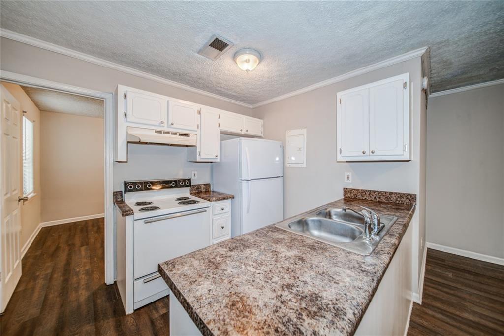 341 West Griffin Street, Unit C Dallas, GA 30132 - Photo 3 of 19 a kitchen with white cabinets and white appliances