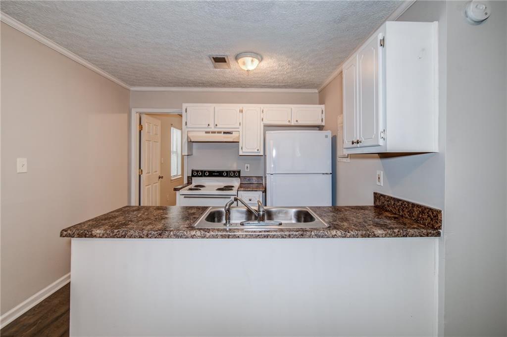 341 West Griffin Street, Unit C Dallas, GA 30132 - Photo 4 of 19 a kitchen with kitchen island granite countertop a sink stove and refrigerator