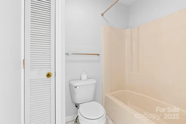a white toilet sitting next to a white tub