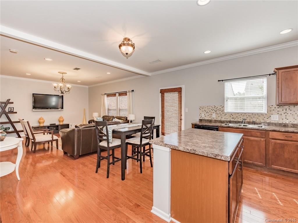 2226 Durand Road Fort Mill, SC 29715 - Photo 10 of 24 a kitchen with stainless steel appliances granite countertop a stove top oven a sink a dining table and chairs with wooden floor