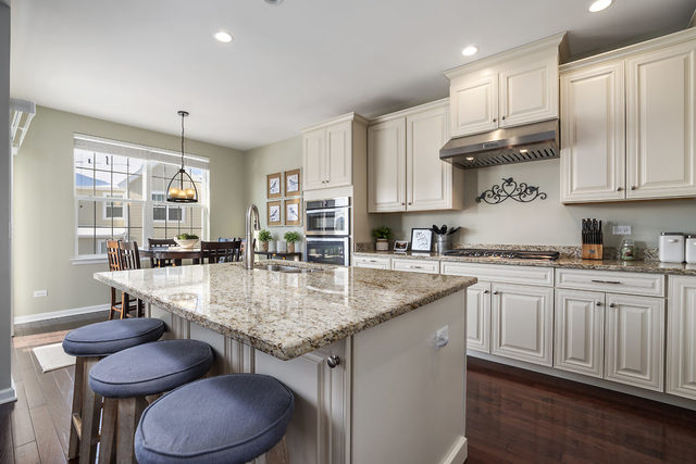 1244 Falcon Ridge Drive Elgin, IL 60124 - Photo 4 of 23 a kitchen with kitchen island granite countertop a table chairs sink and cabinets
