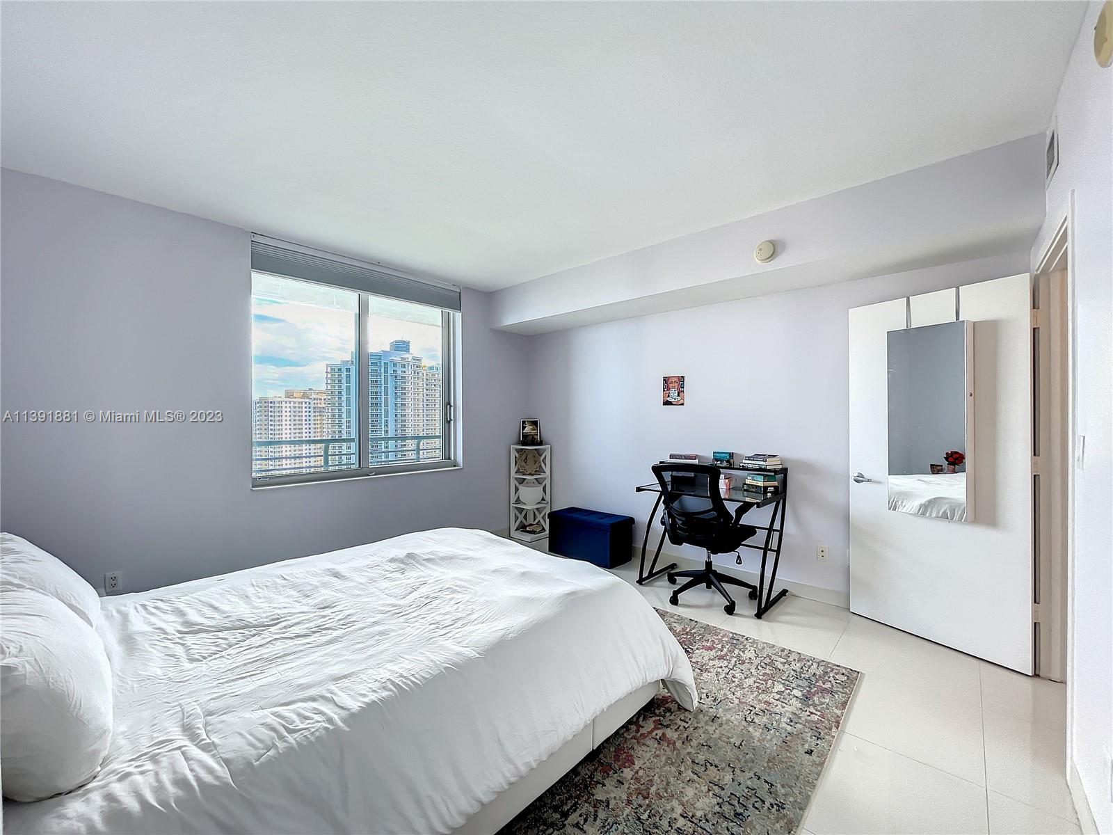 335 South Biscayne Boulevard, Unit 3103 Miami, FL 33131 - Photo 11 of 35 a bedroom with a bed and a chair