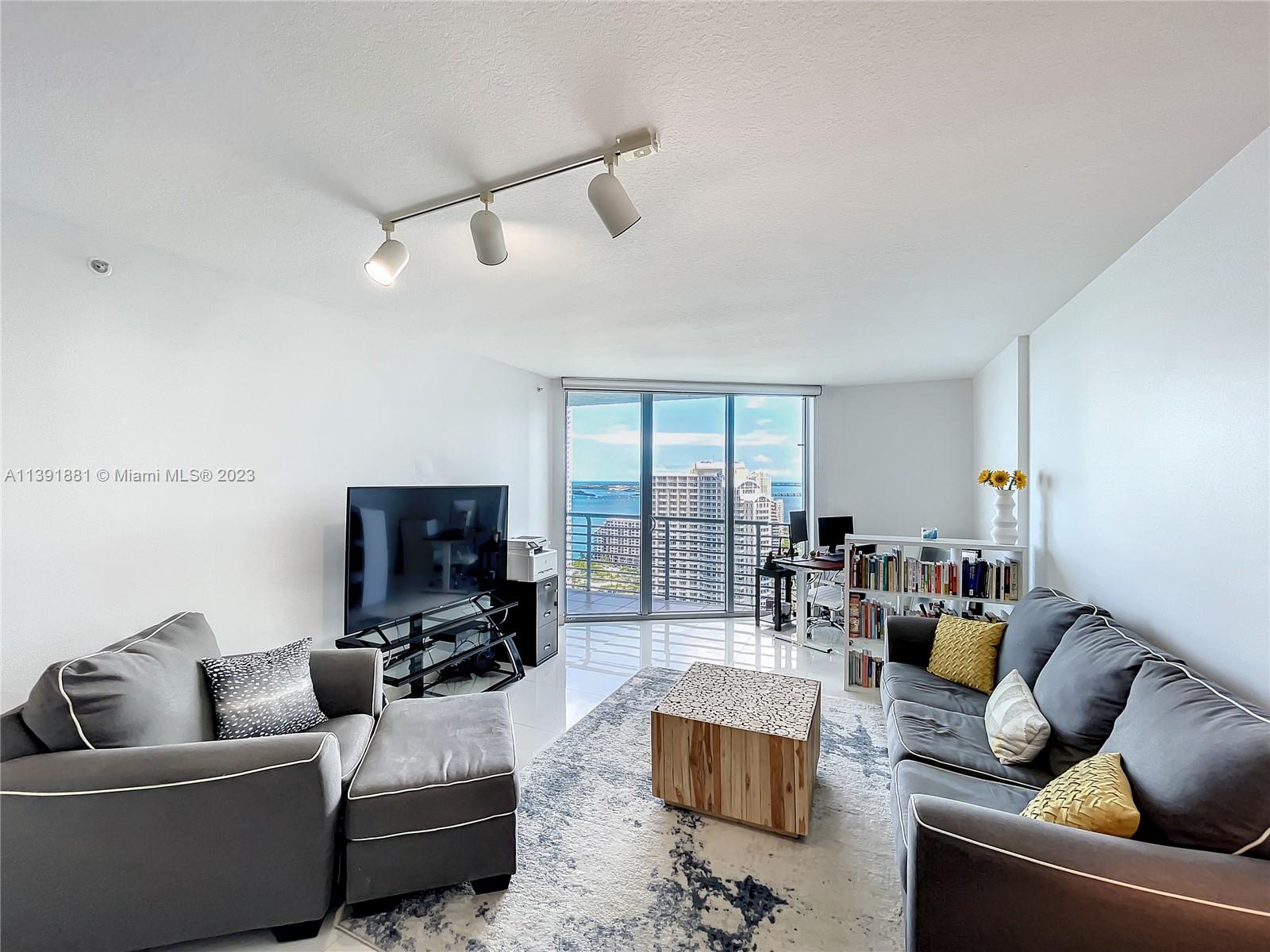335 South Biscayne Boulevard, Unit 3103 Miami, FL 33131 - Photo 2 of 35 a living room with furniture and a flat screen tv