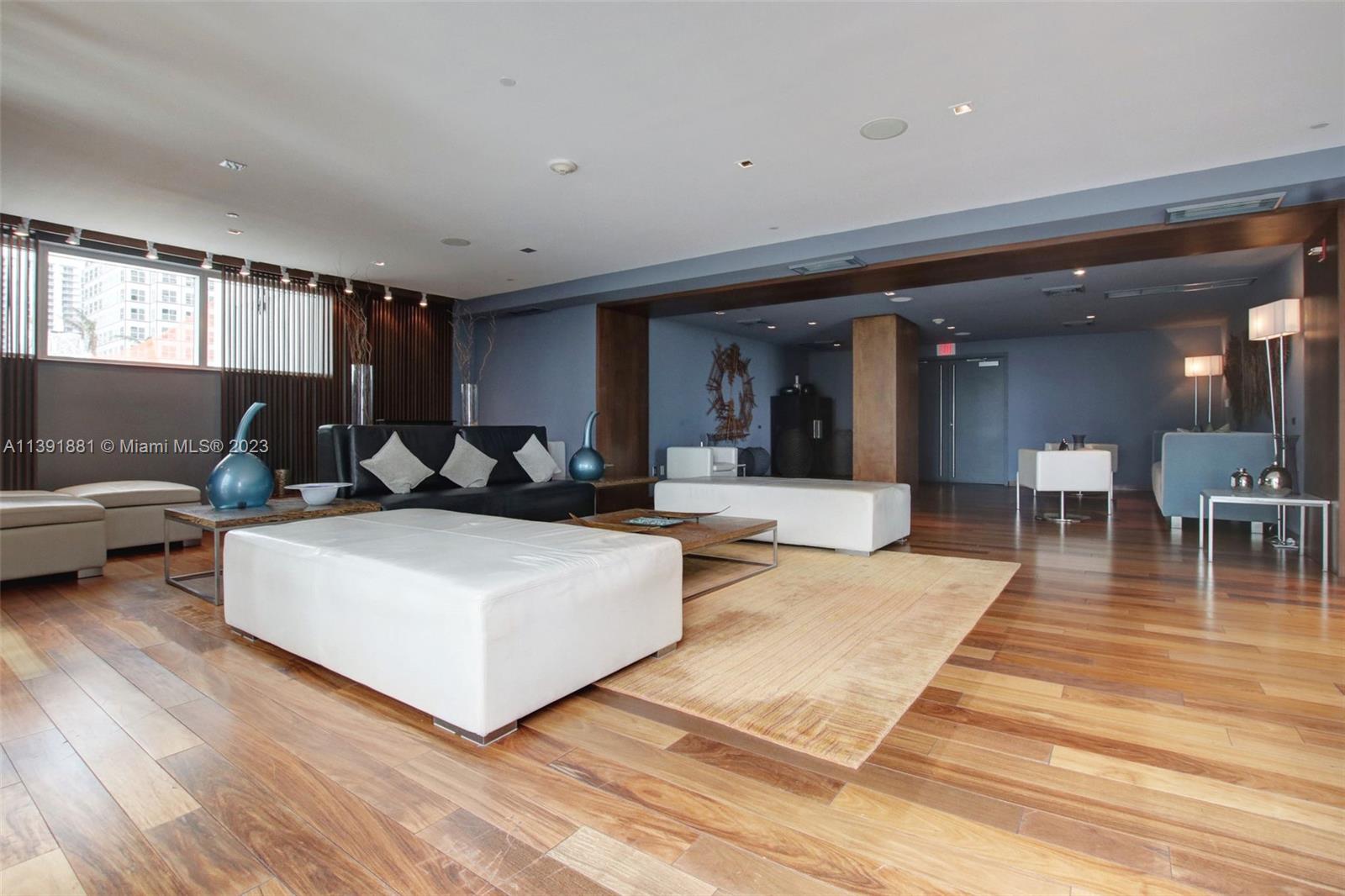 335 South Biscayne Boulevard, Unit 3103 Miami, FL 33131 - Photo 30 of 35 a living room with furniture a dining table and a dining table with wooden floor