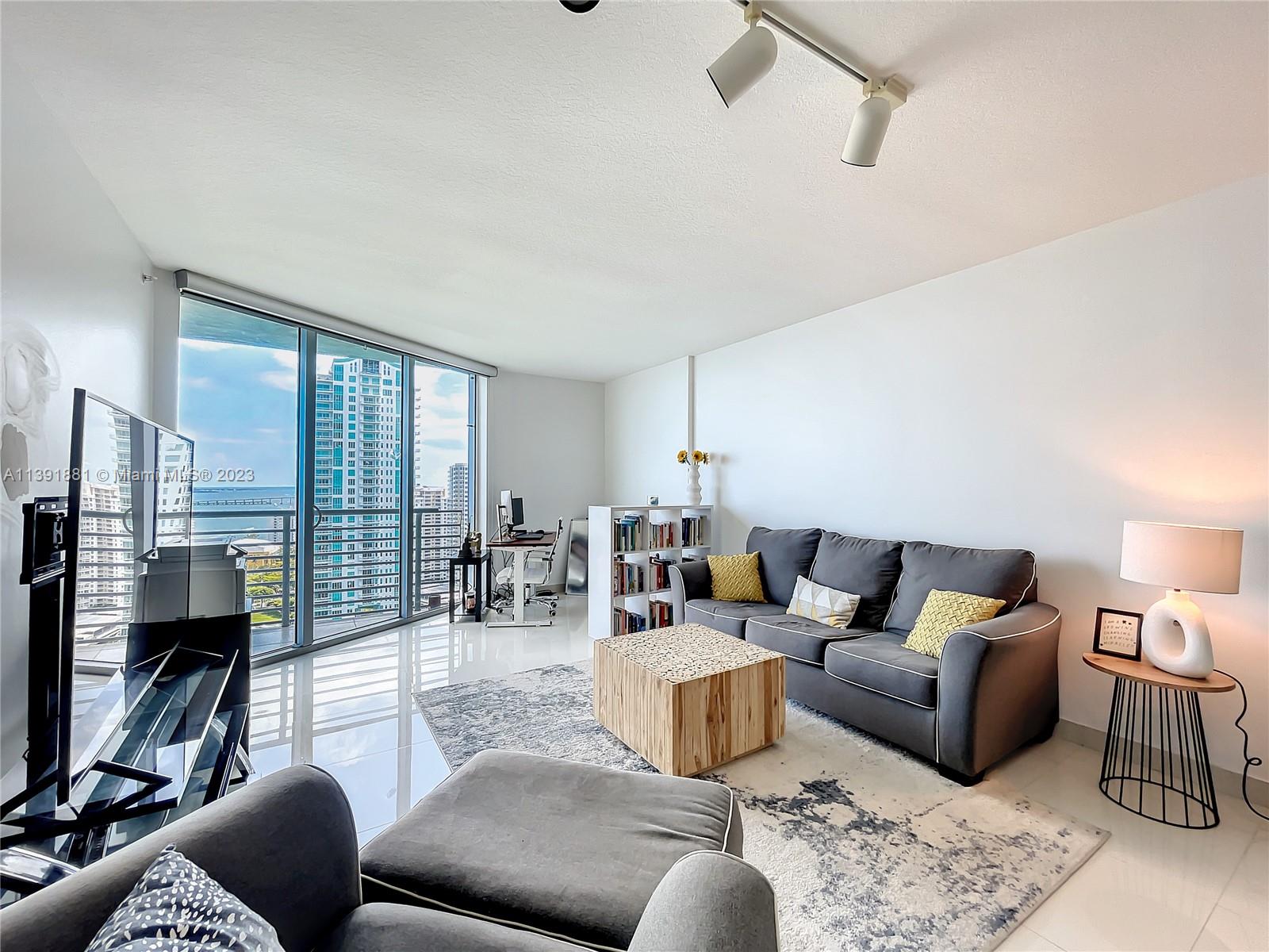 335 South Biscayne Boulevard, Unit 3103 Miami, FL 33131 - Photo 3 of 35 a living room with furniture and a fireplace