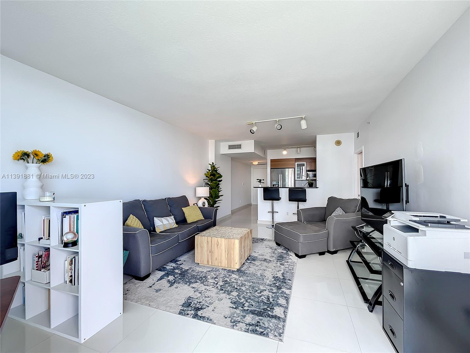 335 South Biscayne Boulevard, Unit 3103 Miami, FL 33131 - Photo 6 of 35 a living room with furniture and a flat screen tv