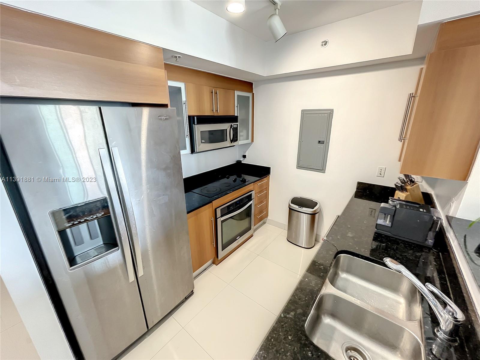 335 South Biscayne Boulevard, Unit 3103 Miami, FL 33131 - Photo 8 of 35 a kitchen with stainless steel appliances a refrigerator a sink a stove a microwave a counter top and cabinets