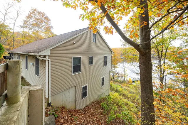 a view of a house with a yard and a large tree