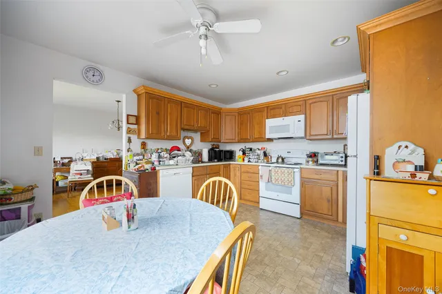 a kitchen with stainless steel appliances granite countertop a dining table chairs stove and refrigerator