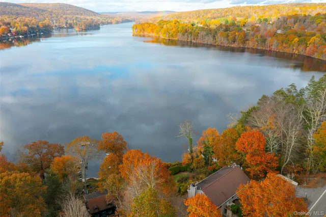 an aerial view of a house with a yard and lake view