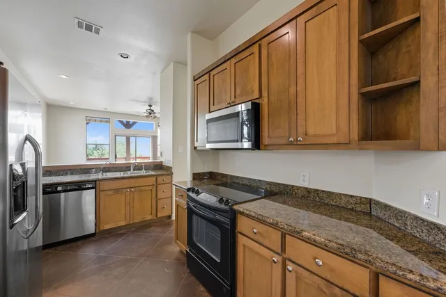a kitchen with stainless steel appliances granite countertop a stove a sink and a microwave