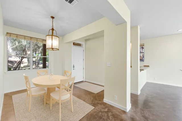 a dining room with furniture a chandelier and window