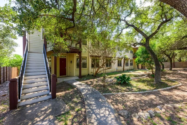 a view of a house with backyard and tree