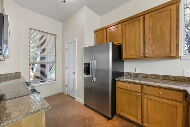 a kitchen with stainless steel appliances granite countertop a refrigerator and a stove top oven