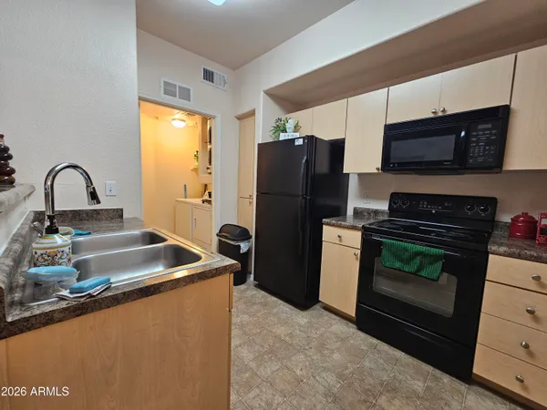 a kitchen with granite countertop a refrigerator and a stove top oven