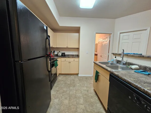 a kitchen with stainless steel appliances granite countertop a refrigerator a sink and a stove