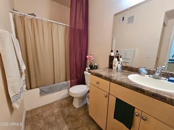 a bathroom with a granite countertop sink toilet and mirror