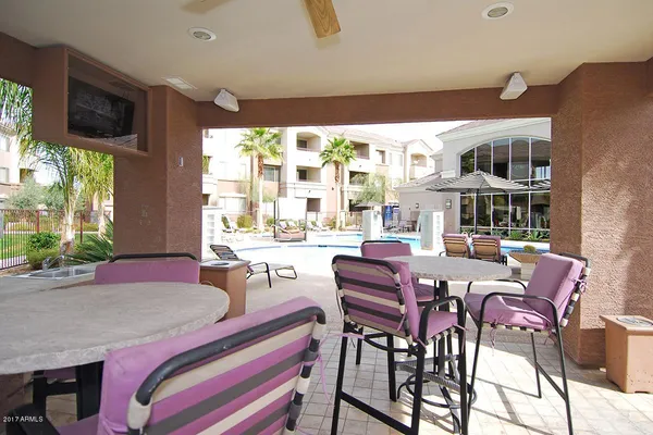 a dining room with furniture a large window and a flat screen tv