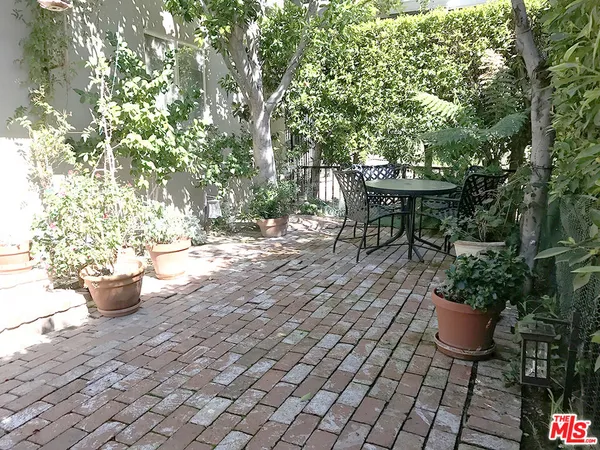 a view of a backyard with chair and potted plants