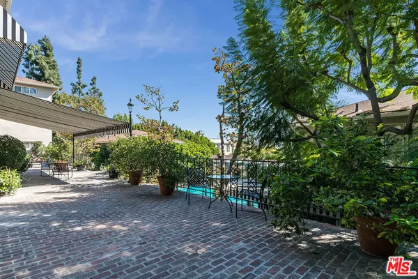 a view of a house with a yard and potted plants