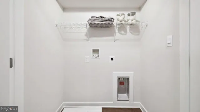 a view of a hallway with white cabinets and wooden floor