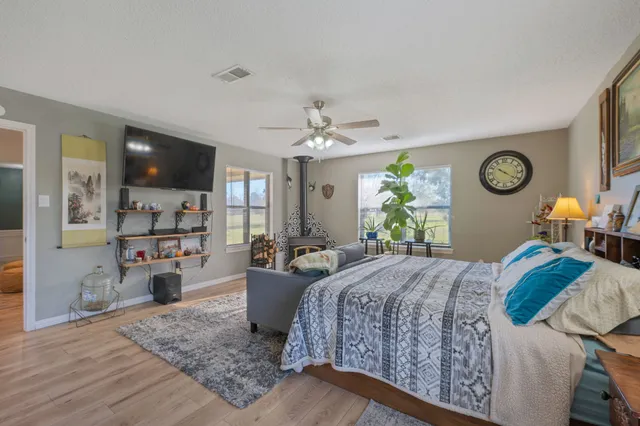 a bedroom with a bed and a large mirror on the dresser