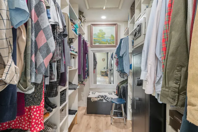 a view of walk in closet with clothes and shoes