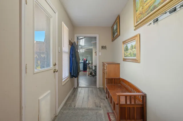 a view of a hallway with wooden floor and staircase