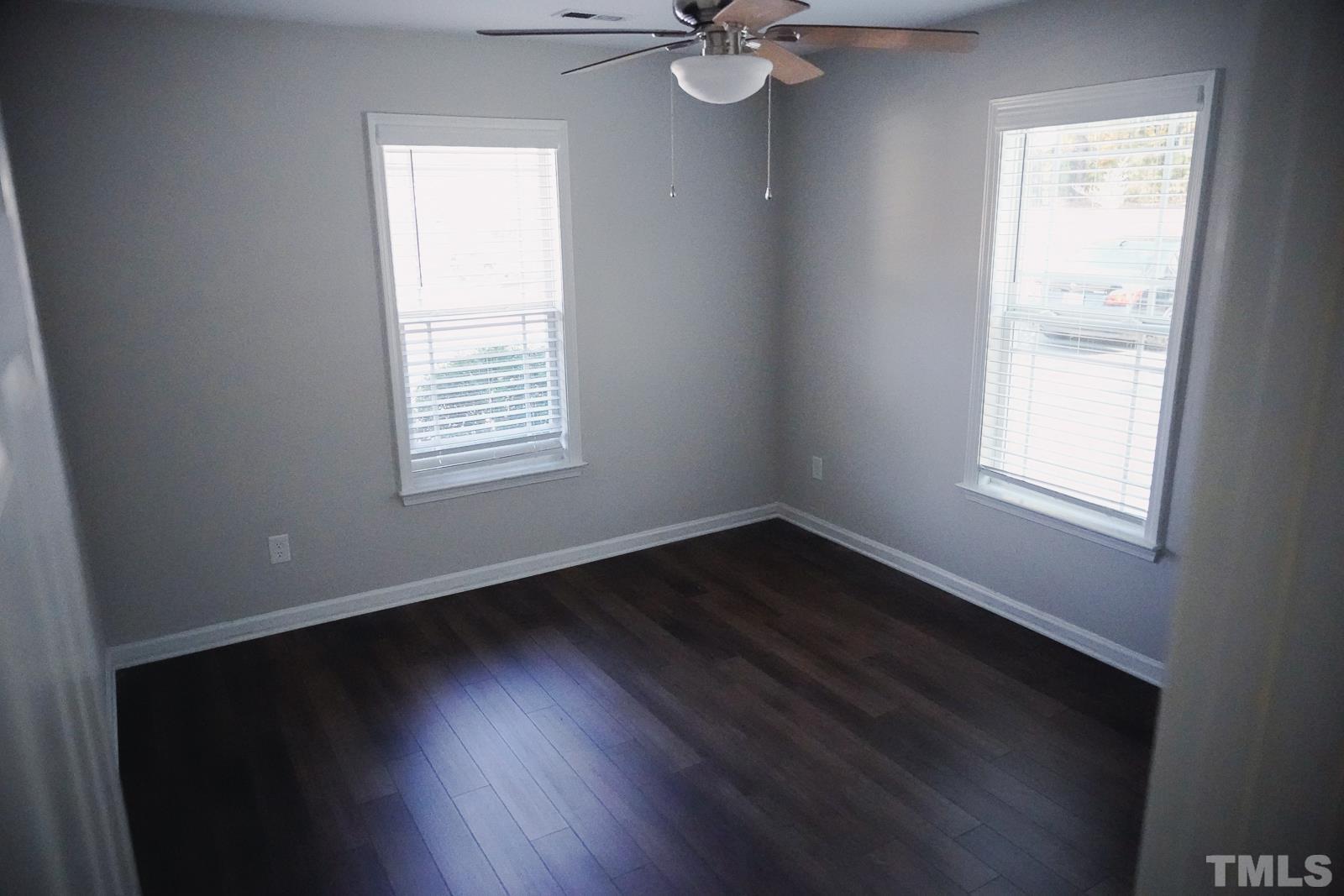1320 South State Street, Unit A Raleigh, NC 27610 - Photo 11 of 20 a view of an empty room with wooden floor and a window