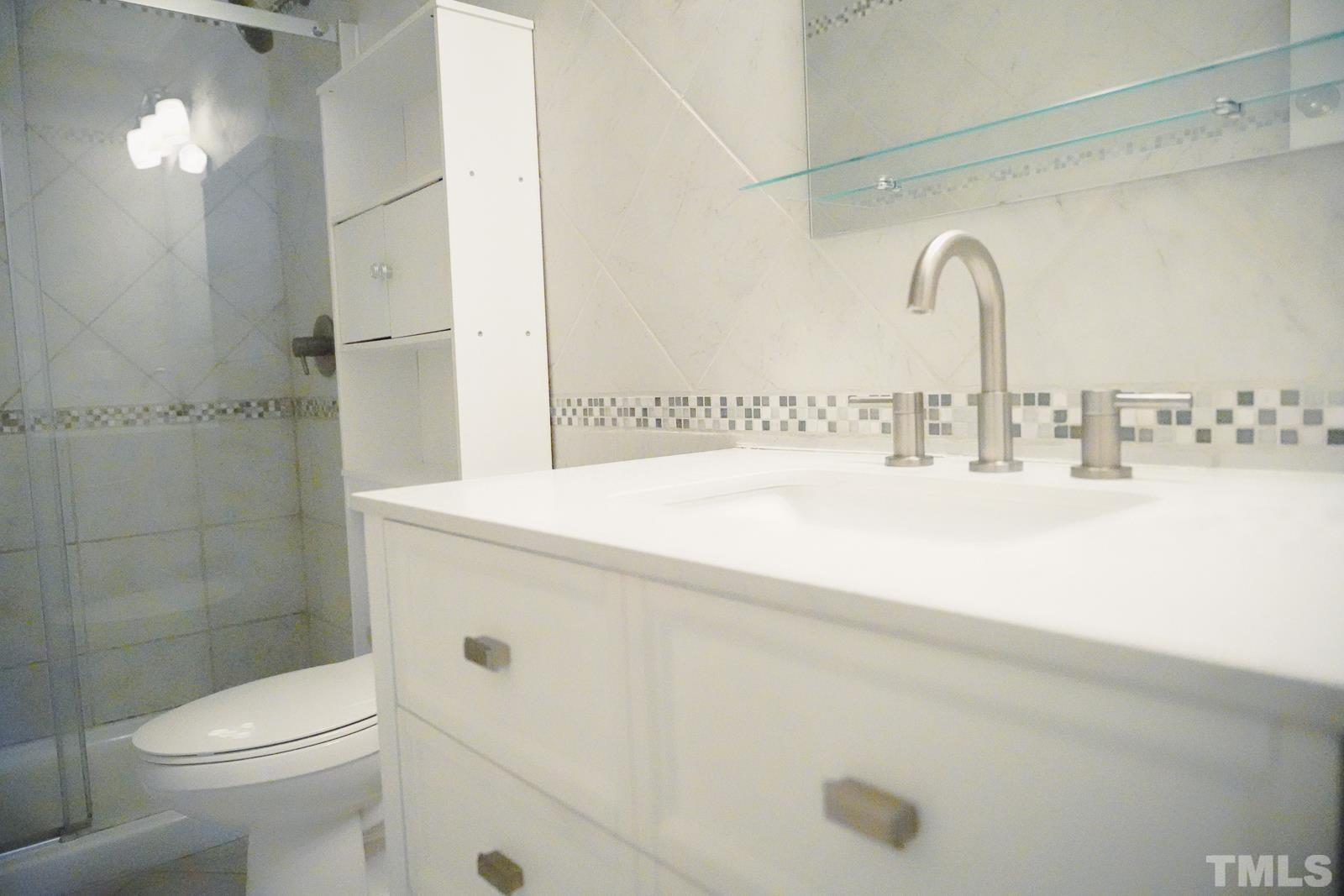1320 South State Street, Unit A Raleigh, NC 27610 - Photo 15 of 20 a bathroom with a sink mirror toilet and shower