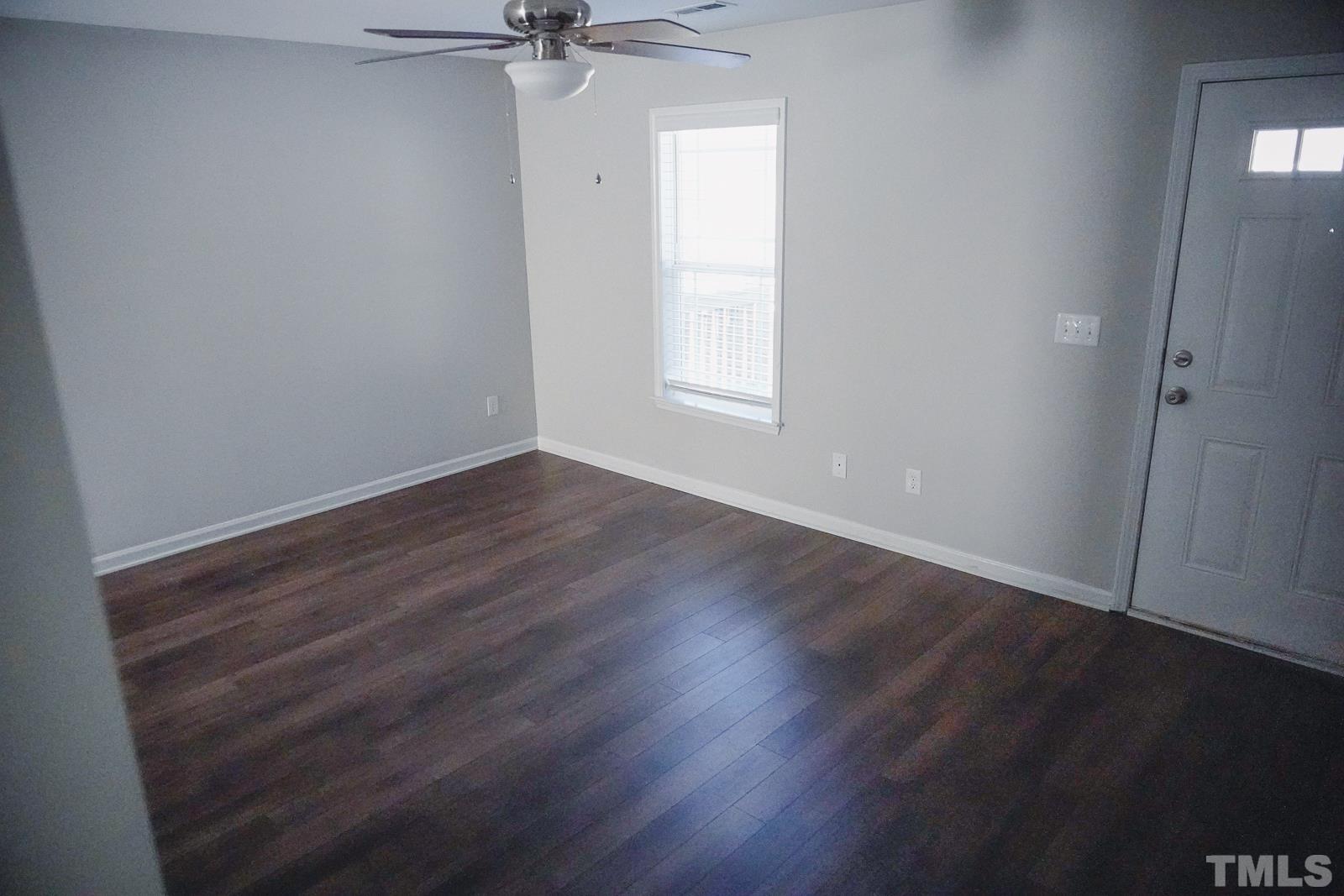 1320 South State Street, Unit A Raleigh, NC 27610 - Photo 4 of 20 an empty room with wooden floor closet and windows