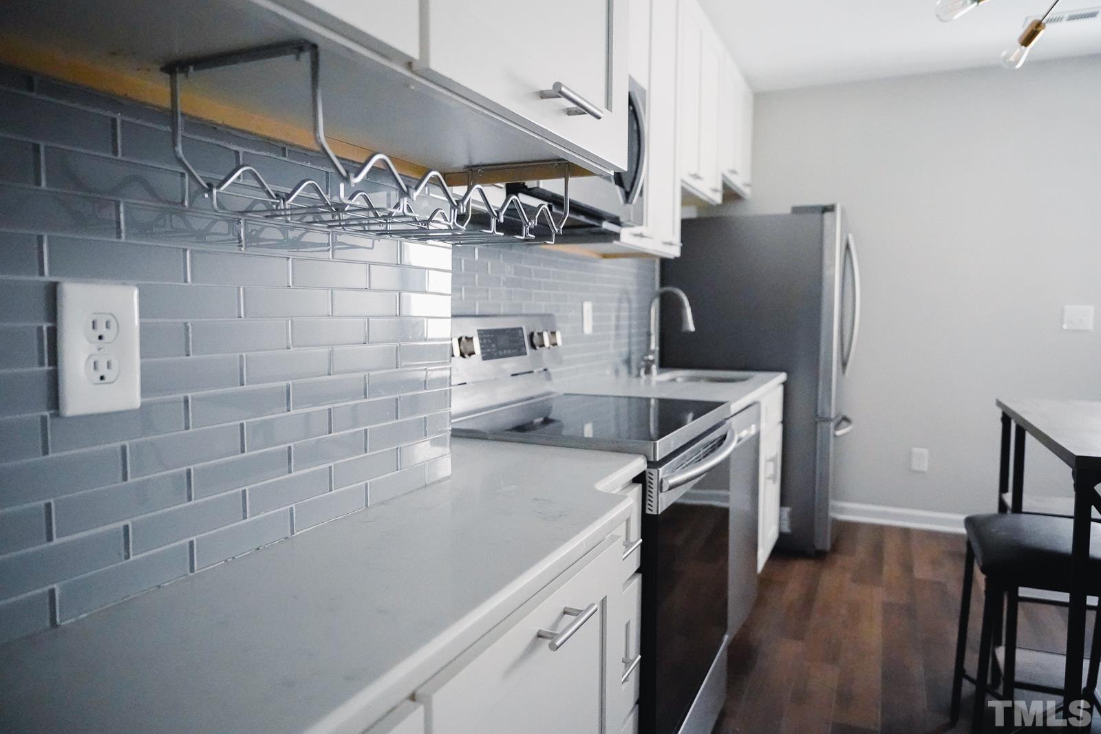 1320 South State Street, Unit A Raleigh, NC 27610 - Photo 5 of 20 a kitchen with stainless steel appliances a sink stove and refrigerator
