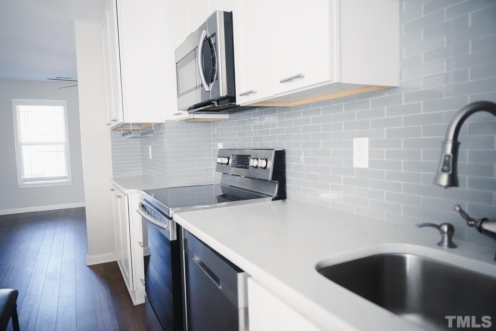1320 South State Street, Unit A Raleigh, NC 27610 - Photo 7 of 20 a kitchen with stainless steel appliances granite countertop a sink a stove and a wooden floors