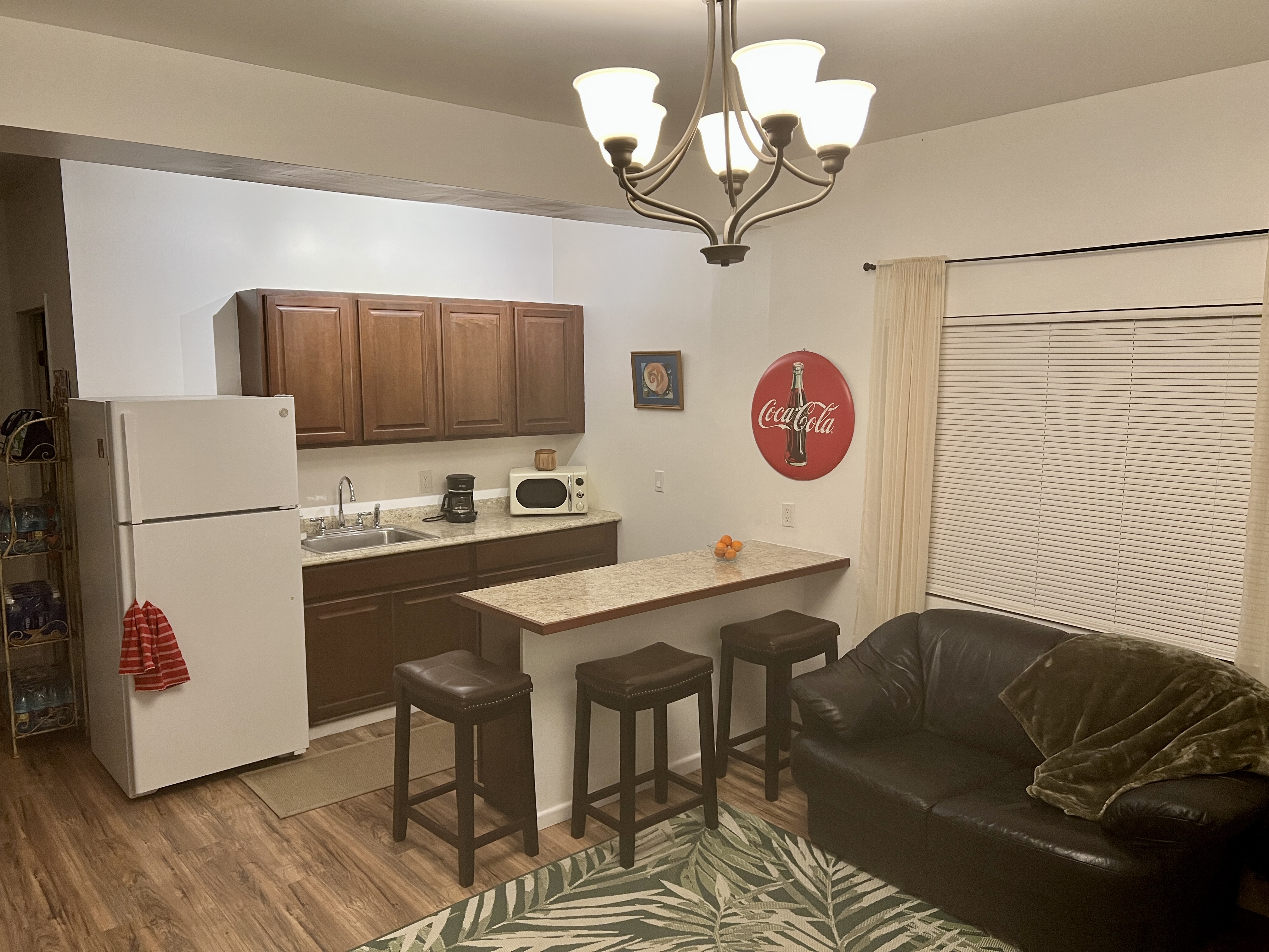 11-2485 Omeka Road Mountain View, HI 96771 - Photo 10 of 30 a kitchen with stainless steel appliances granite countertop a refrigerator a sink dishwasher a dining table and chairs with wooden floor