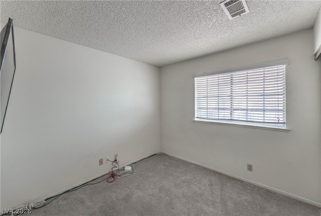 581 Carleton Drive Henderson, NV 89014 - Photo 19 of 37 Well-lit room with plush carpeting and natural light filtering through window blinds.