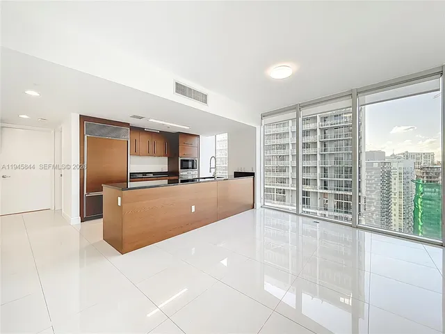 a view of kitchen with kitchen island a counter top space a sink and cabinets