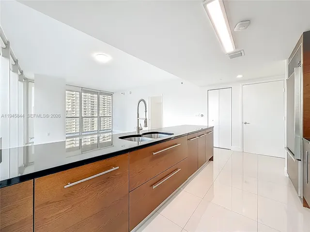 a large white kitchen with a large window