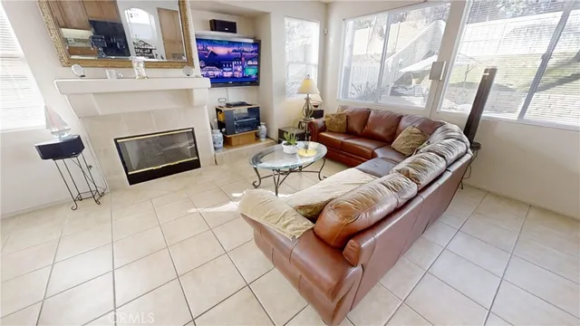 a living room with furniture a fireplace and a large window