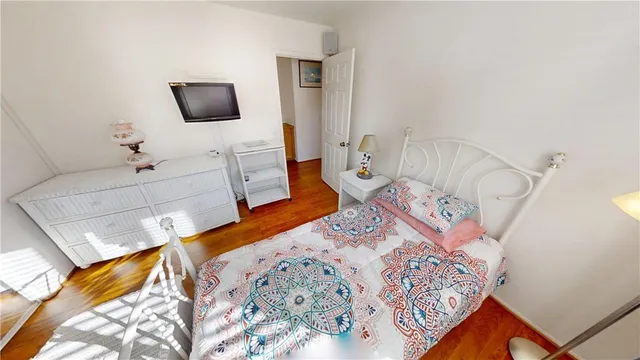 a bedroom with a bed and a mirror on dresser