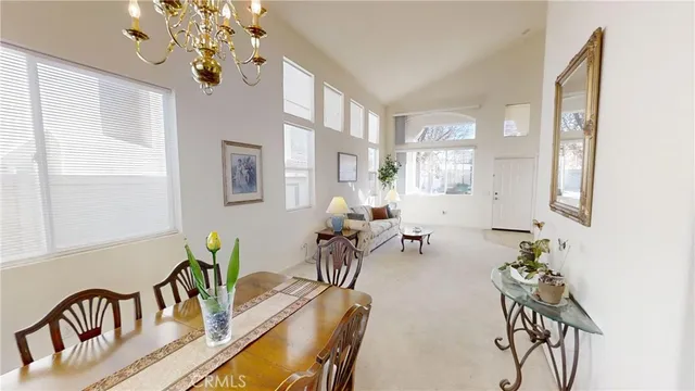 a view of a dining room with furniture a chandelier and a window