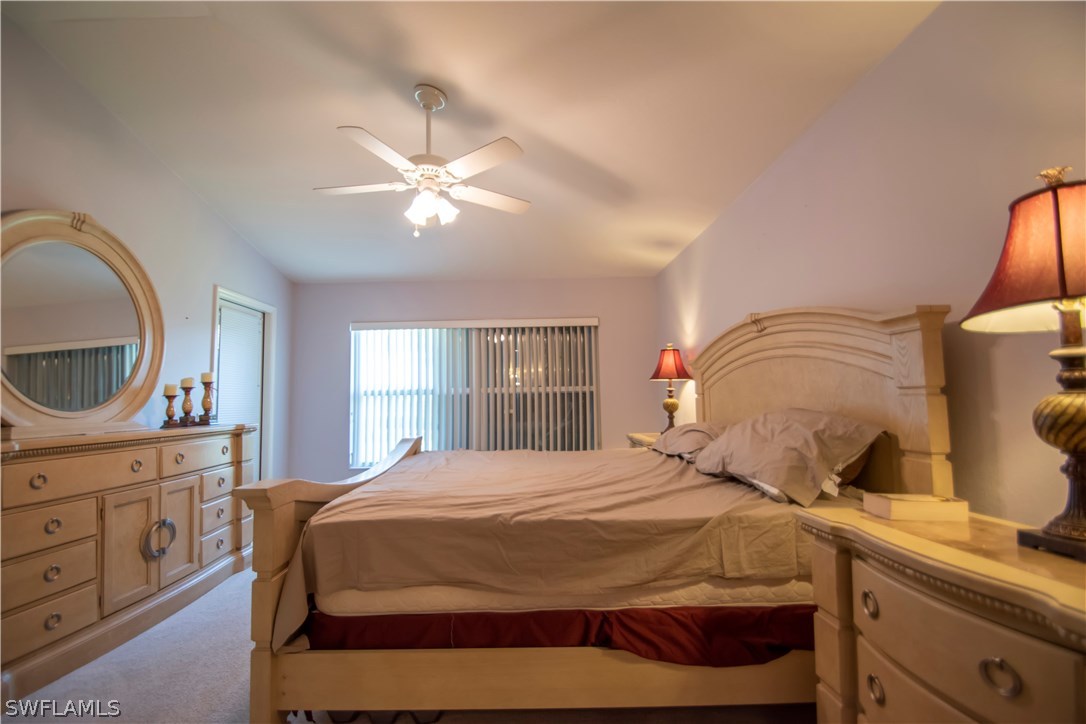 8879 Falcon Pointe Loop Fort Myers, FL 33912 - Photo 12 of 17 a bedroom with a bed and a chandelier