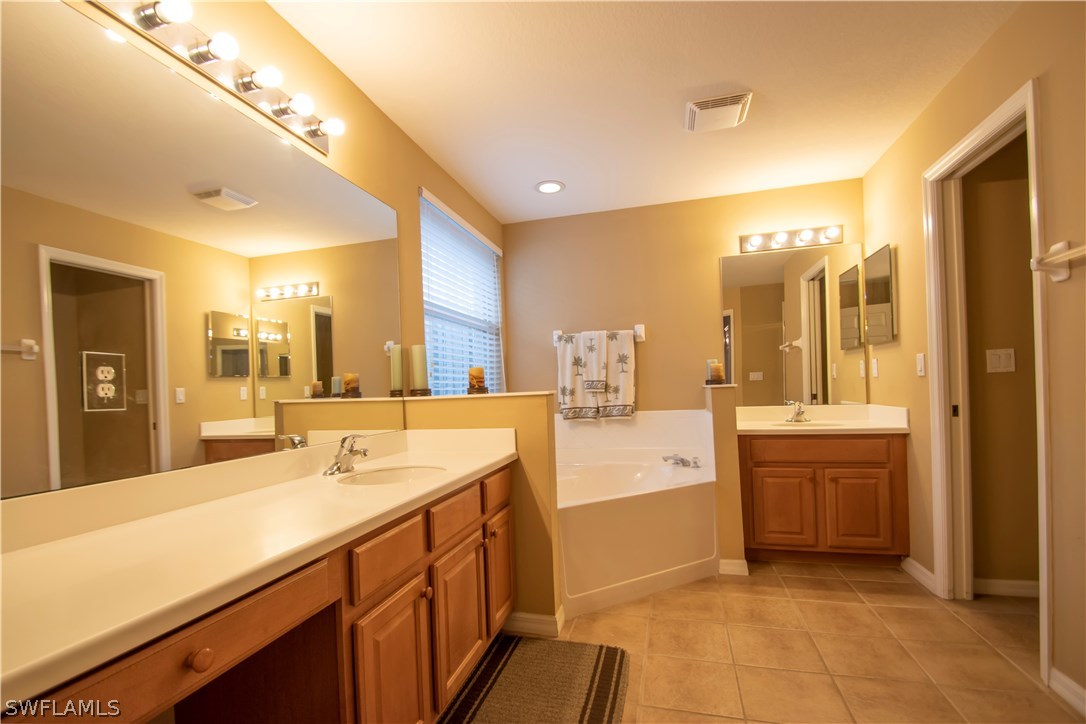 8879 Falcon Pointe Loop Fort Myers, FL 33912 - Photo 13 of 17 a spacious bathroom with a sink mirror and a bath tub