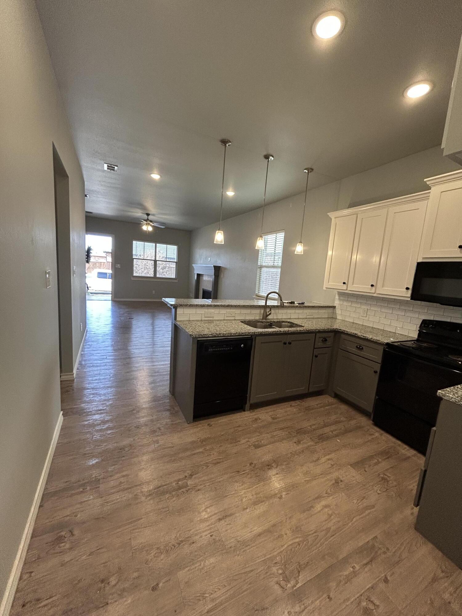 4717 121st Place Lubbock, TX 79424 - Photo 3 of 10 a large kitchen with stainless steel appliances granite countertop a sink counter space cabinets and a window