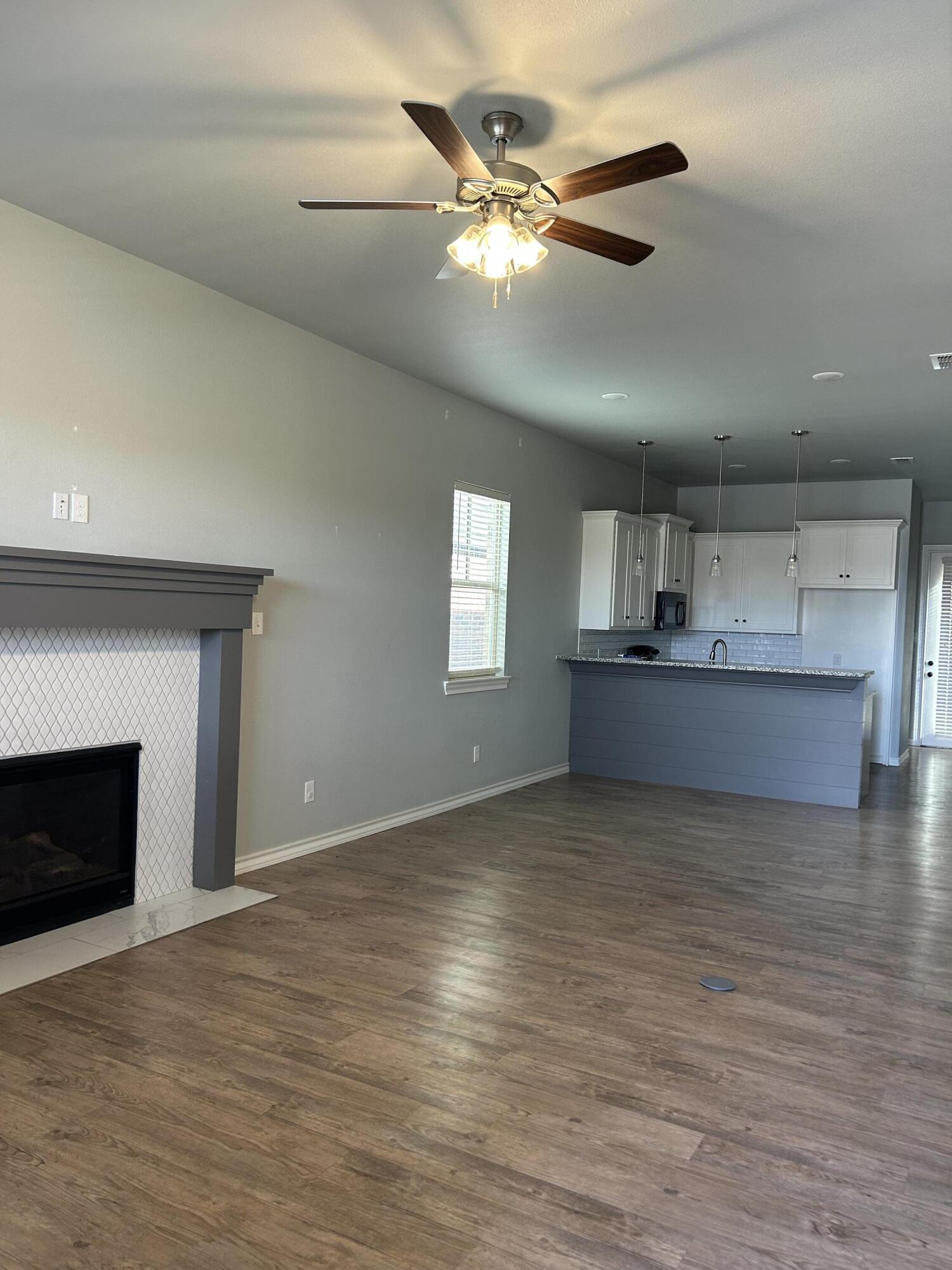4717 121st Place Lubbock, TX 79424 - Photo 4 of 10 a view of an empty room with a fireplace and a window