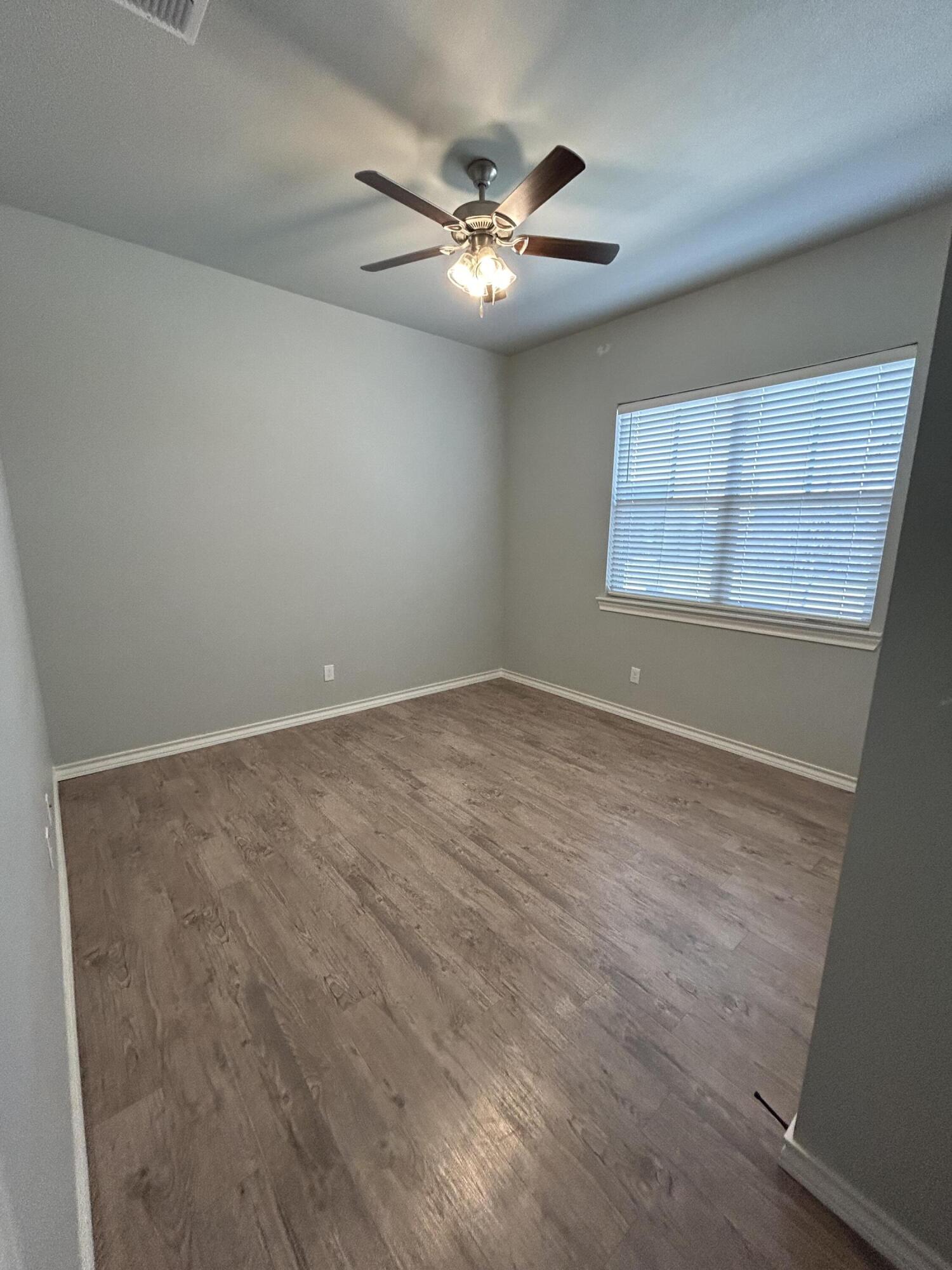 4717 121st Place Lubbock, TX 79424 - Photo 6 of 10 an empty room with a window and a ceiling fan