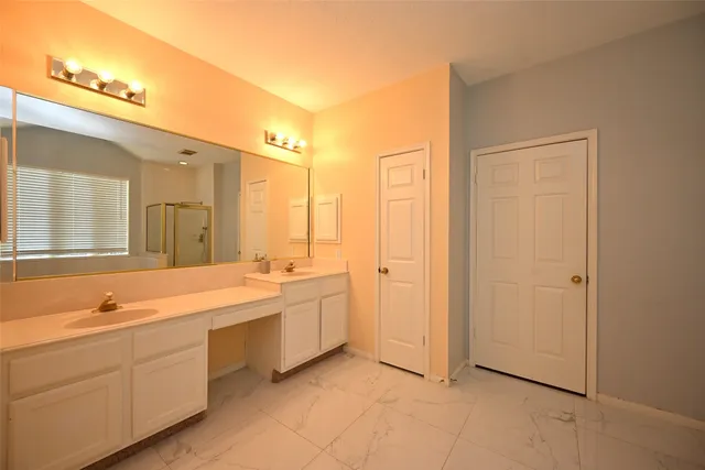 a spacious bathroom with a double vanity sink a mirror and a bathtub